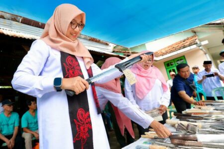 Bupati Banyuwangi tengah mencoba menghunus keris.