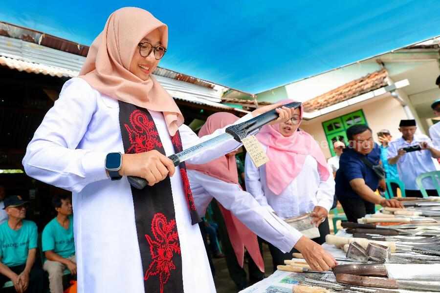 Bupati Banyuwangi tengah mencoba menghunus keris.