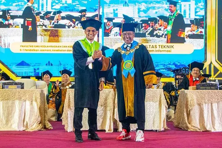 Rachmat Irianto berjabat tangan dengan Rektor Unesa Prof Nurhasan di momen wisuda.