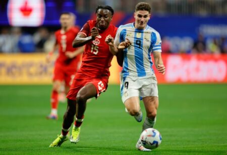 Moïse Bombito dari Kanada dan Julian Alvarez dari Argentina berebut bola pada babak pertama. Foto: Getty Images