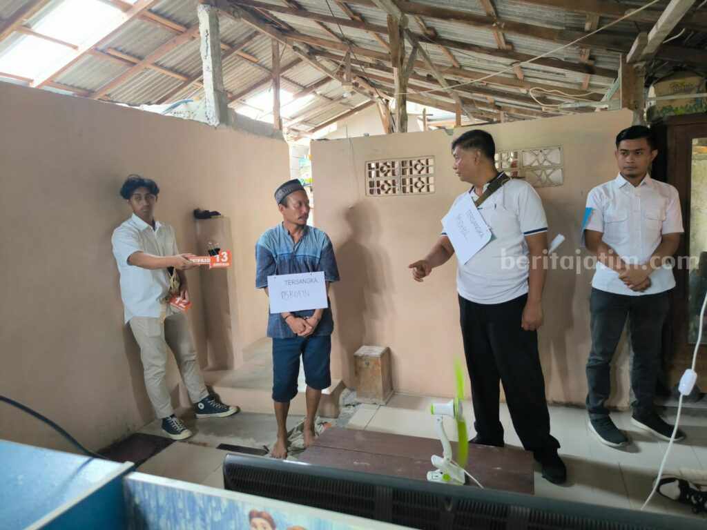 Foto tersangka Asrofin (tengah) saat menjalankan 27 adegan rekontruksi kasus pembunuhan yang terjadi di Desa Imaan Kecamatan Dukun, Gresik
