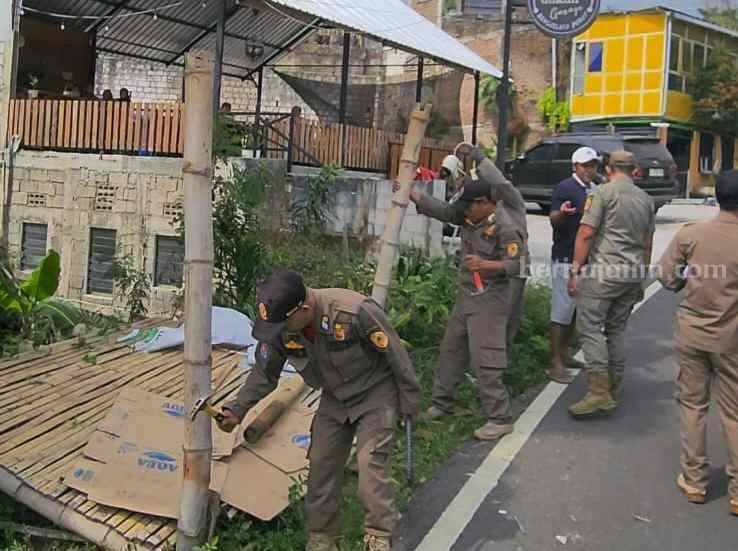 Petugas membongkar paksa pos penjaja sewa villa di kawasan wisata di Kecamatan Pacet, Kabupaten Mojokerto. [Foto : ist]