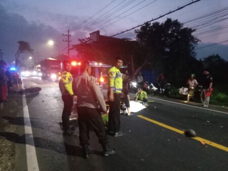 Foto polisi saat mengevakuasi korban usai terjadi kecelakaan truk tangki dengan dua pengendara motor.