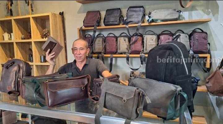 Sadzily (57) saat menunjukkan koleksi kerajinan kulit buatannya. [Foto : Misti/beritajatim.com]
