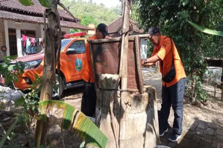 Petugas mengecek debit air sumur milik warga yang desanya berpotensi mengalami kekeringan. (Foto/BPBD Ponorogo)