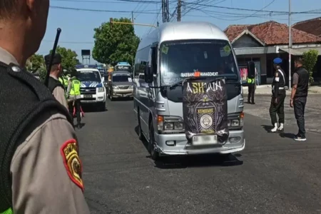 Pemberangkatan pesilat PSHWTM asal Ponorogo yang melintasi perempatan pos polisi Mlilir. (Foto/Endra Dwiono/Beritajatim.com)
