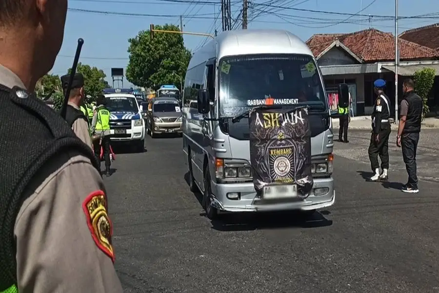 Pemberangkatan pesilat PSHWTM asal Ponorogo yang melintasi perempatan pos polisi Mlilir. (Foto/Endra Dwiono/Beritajatim.com)