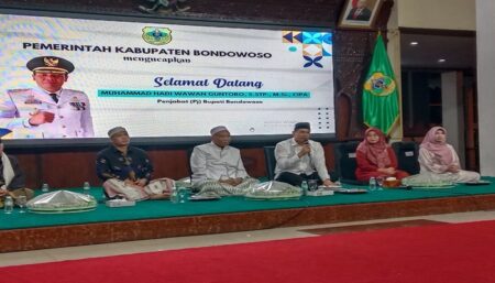 Pj Bupati Bondowoso, Muhammad Hadi Wawan Guntoro (pegang mic) saat tasyakuran dan doa bersama di Pendopo, Selasa (23/7/2024) malam. (Deni Ahmad Wijaya/BeritaJatim.com)