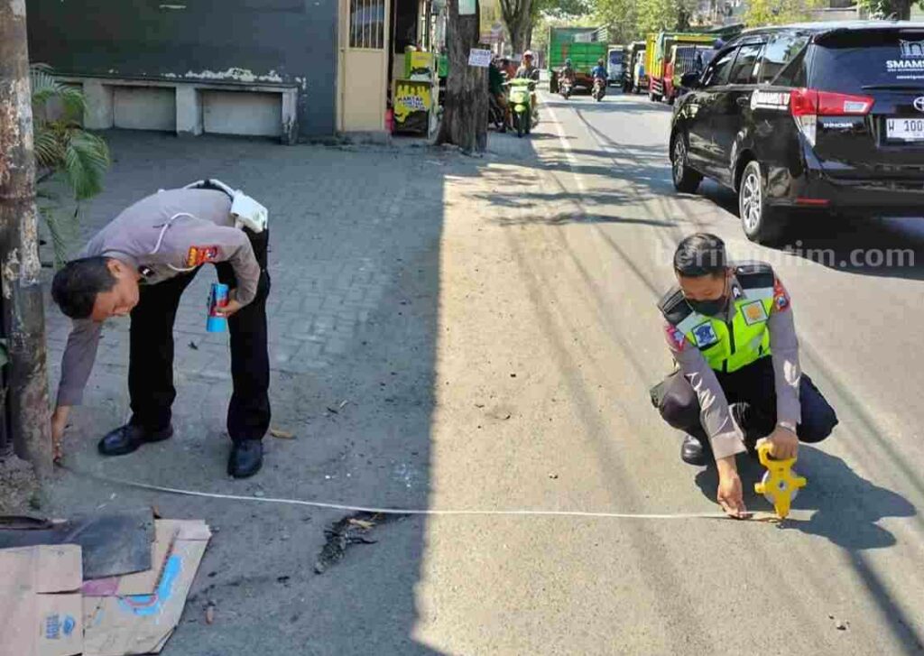 Kecelakaan di Gresik Dua Orang Luka, Seorang Balita Meninggal Dunia Foto dua anggota polisi melakukan olah TKP pengendara motor mengalami kecelakaan.