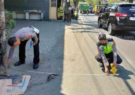 Foto dua anggota polisi melakukan olah TKP pengendara motor mengalami kecelakaan.