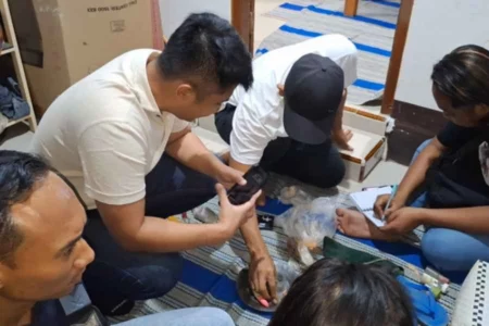 Polisi saat memeriksa barang penambang emas dan koin kuno yang ditemukan meninggal di pinggir Bengawan Madiun di Kelurahan Pelem Ngawi, Selasa (09/07/2024) malam.