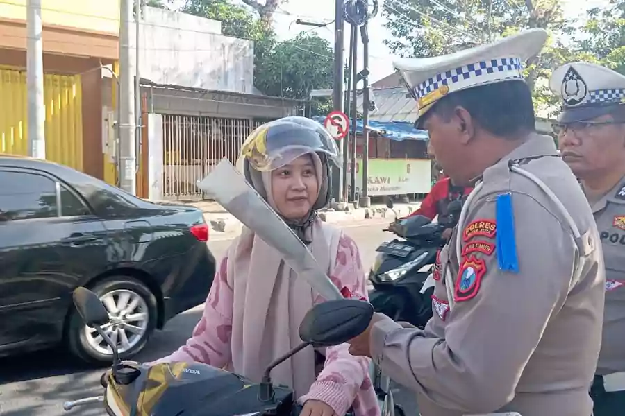 Ahwa pelajar SMK Negeri 2 Blitar menerima bunga dan coklat dari Satlantas Polres Blitar Kota, Rabu (24/07/2024). (Foto : Winanto/beritajatim.com)