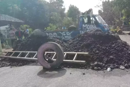 Warga protes ke pemerintah dengan tutup jalan menggunakan pikap dan pohon pisang.
