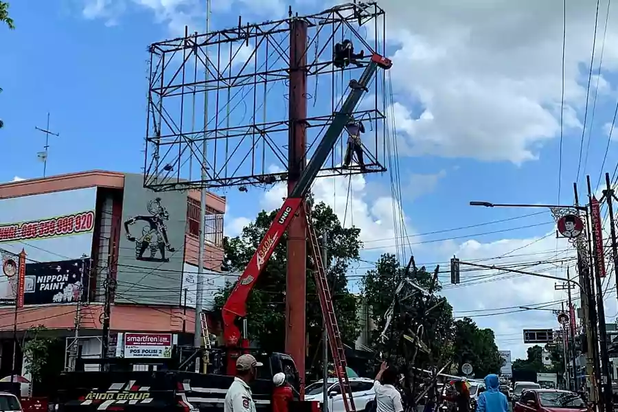 Pembongkaran papan reklame di Jalan Merdeka Kota Blitar, Kamis (11/07/2024). (Foto: Winanto/beritajatim.co)