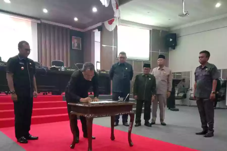 Ketua DPRD Kabupaten Bondowoso membubuhkan tanda tangan dalam rapat paripurna persetujuan Raperda RPJPD 2025-2045 di Graha Paripurna, Sabtu (20/7/2024) siang. (Deni Ahmad Wijaya/Beritajatim.com)