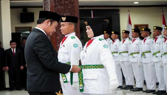 Bupati Lamongan, Yuhronur Efendi, mengukuhkan Paskibra yang akan bertugas dalam upacara peringatan HUT ke-79 RI, di Pendopo Lokatantra, Kamis (15/8/2024) malam.