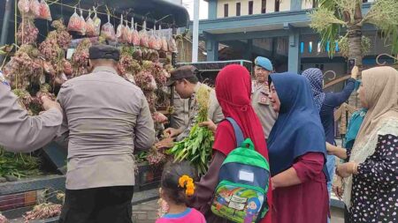 Foto polisi membagikan paket sayur-mayur kepada warga yang membutuhkan.