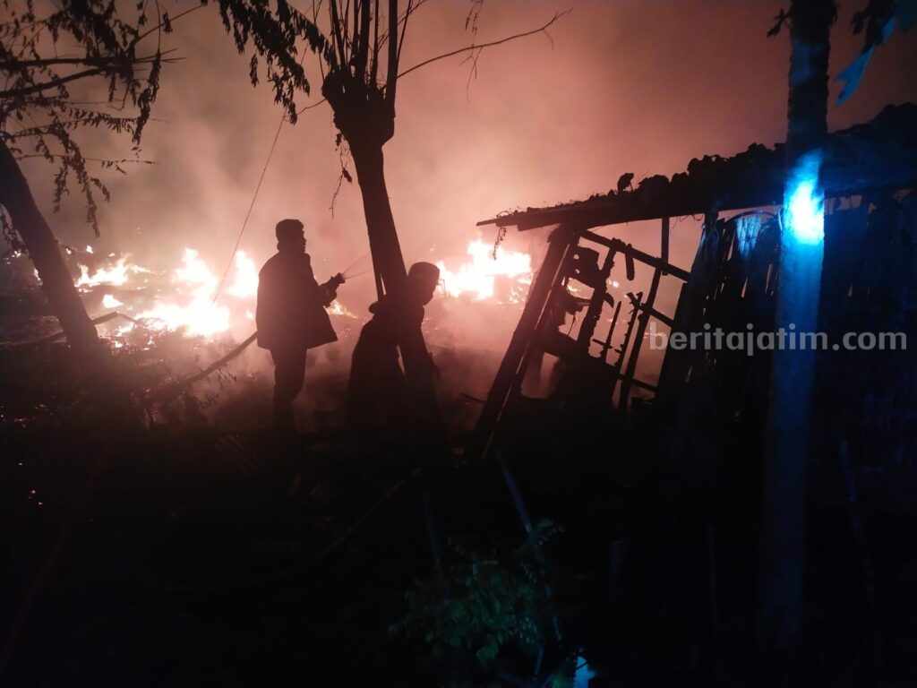 Foto petugas Damkarla Gresik memadamkan api yang menghanguskan kandang sapi dan kambing