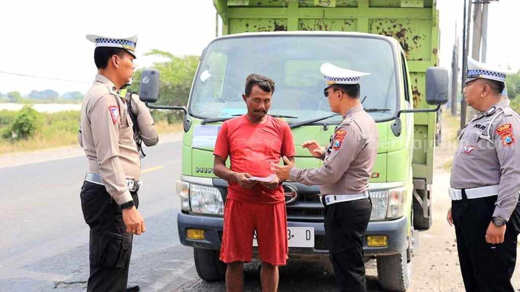 Foto anggota Satlantas Polres Gresik melakukan penilangan terhadap truk yang melanggar aturan tanpa terpal