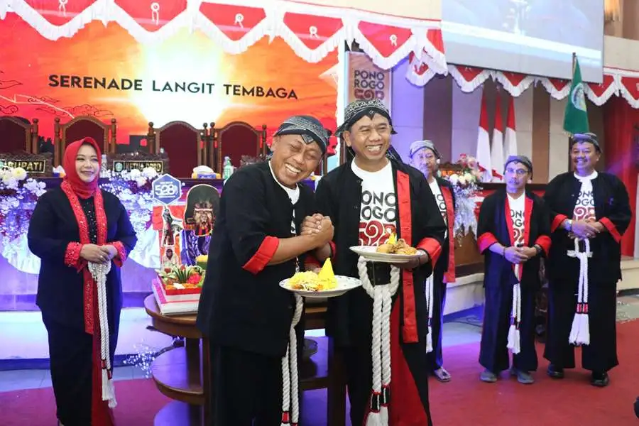 Ketua DPRD Ponorogo bersalaman erat dengan Bupati Sugiri Sancoko usai bertukar tumpeng dalam rapat paripurna peringatan hari jadi ke-528 Kabupaten Ponorogo. (Foto/DPRD Ponorogo)