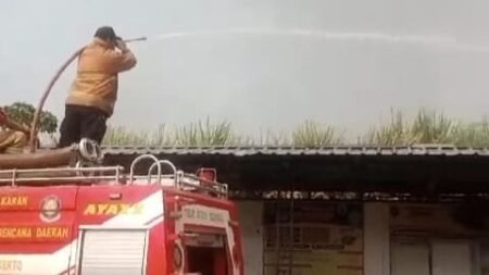 Petugas Damkar melakukan proses pemadaman di lahan tanaman tebu di belakang Balai Desa Jatipasar, Kecamatan Trowulan, Kabupaten Mojokerto. [Foto: Ist]