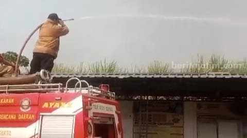 Petugas Damkar melakukan proses pemadaman di lahan tanaman tebu di belakang Balai Desa Jatipasar, Kecamatan Trowulan, Kabupaten Mojokerto. [Foto: Ist]