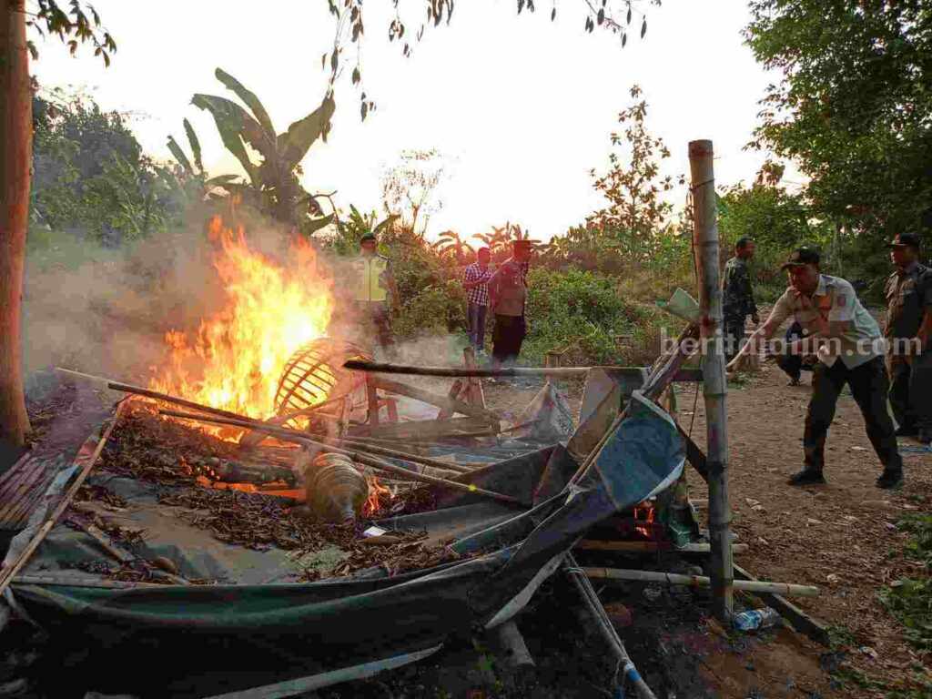 Petugas gabungan membongkar dan membakar arena judi sabung ayam di di Desa Kedungmaling, Kecamatan Sooko, Kabupaten Mojokerto. [Foto : ist]