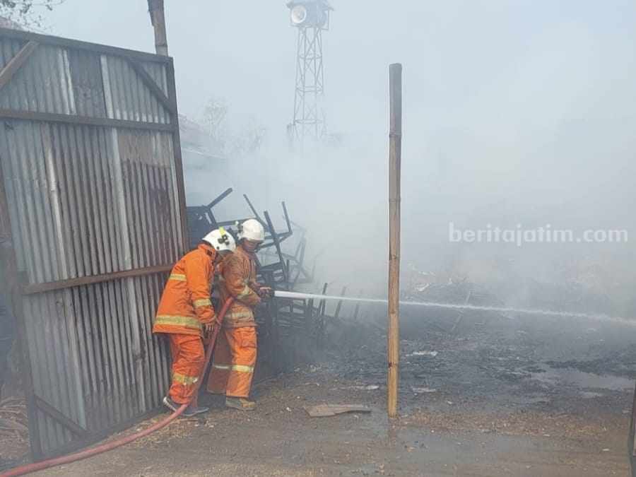 Petugas memadamkan api yang membakar gudang rongsokan di Dusun Ngimbangan, Desa Nambangan, Kecamatan Mojosari, Kabupaten Mojokerto.