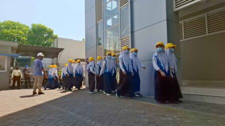 Foto puluhan siswa mengikuti wisata industri sebelum memasuki ruang produksi