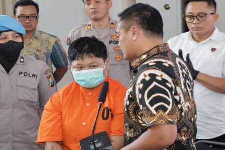 Tersangka Putri saat dirilis di Polrestabes Surabaya (kiri).