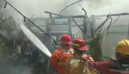 Tiga Rumah di Gresik Hangus Dilalap si Jago Merah Foto tiga petugas Damkarla Gresik memadamkan api yang menghanguskan tiga rumah