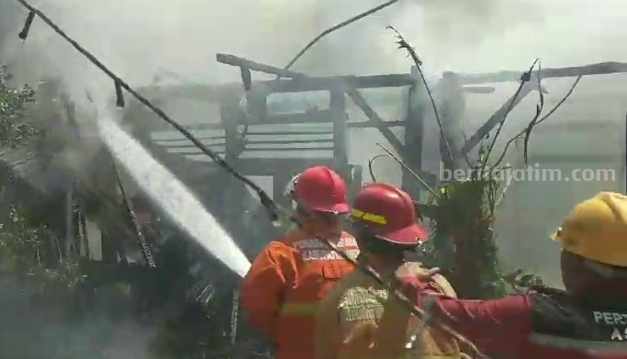 Foto tiga petugas Damkarla Gresik memadamkan api yang menghanguskan tiga rumah