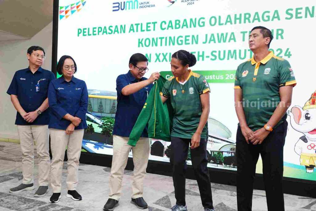 Foto pembina olahraga bola voli Petrokimia Gresik, Dwi Satryo Annurogo menyematkan jaket kebesaran Jatim pada atlet Mediol Stiovanny Yoku