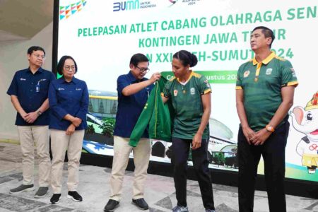 Foto pembina olahraga bola voli Petrokimia Gresik, Dwi Satryo Annurogo menyematkan jaket kebesaran Jatim pada atlet Mediol Stiovanny Yoku