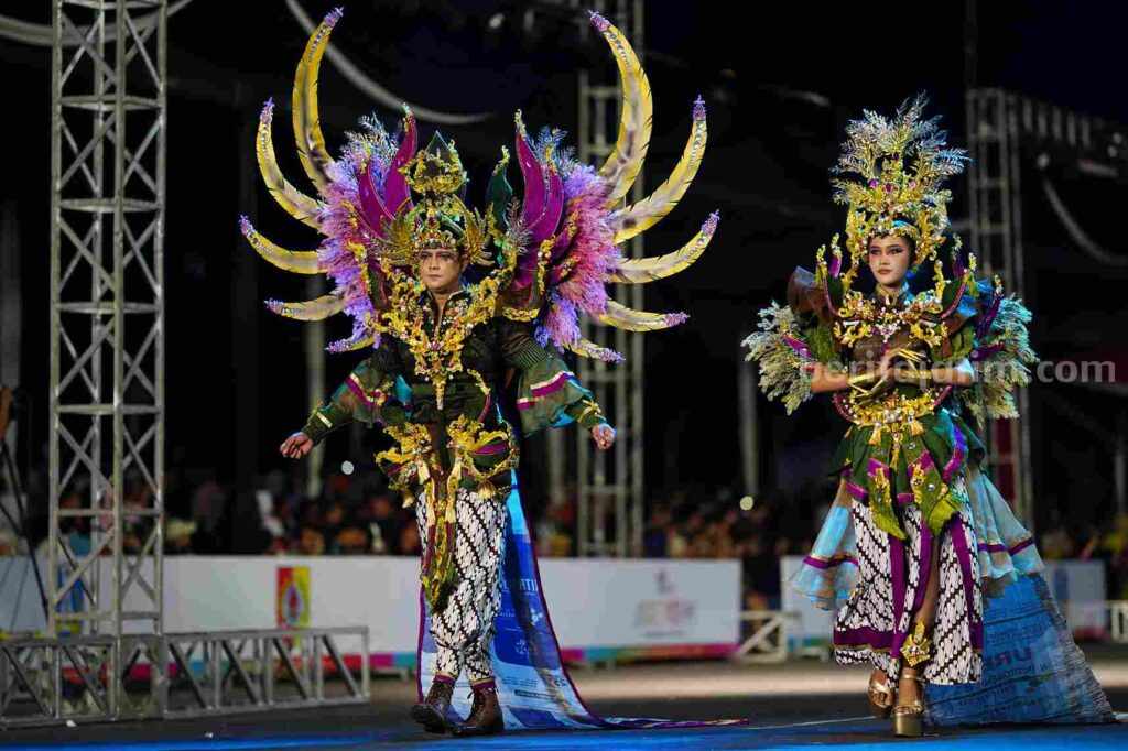 Foto dua model memamerkan batik tradisional di event fashion internasional.