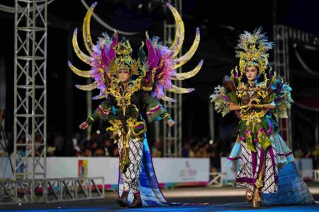 Foto dua model memamerkan batik tradisional di event fashion internasional.