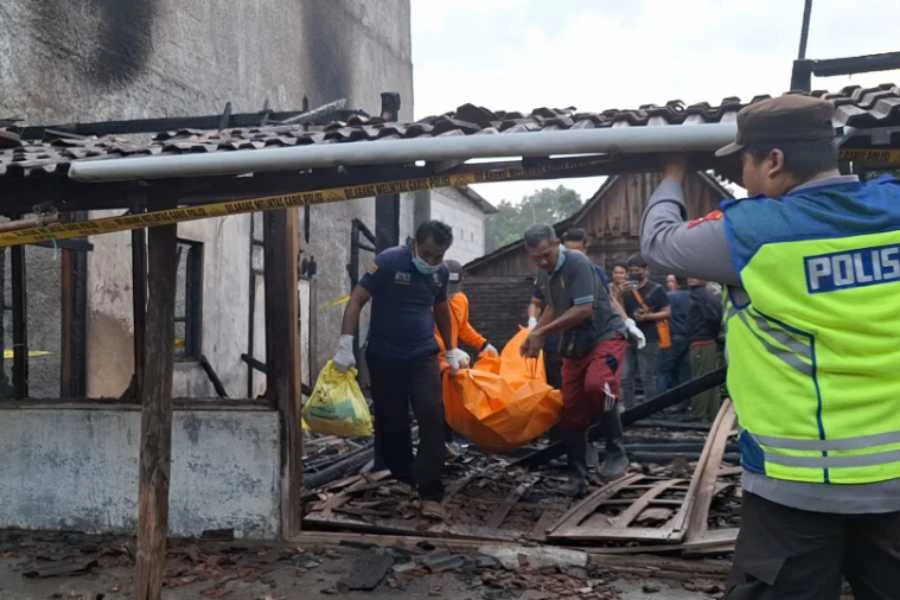 Caption: Petugas saat mengevakuasi jenazah Winarno (37) yang meninggal karena rumahnya di Desa Kedungharjo, Mantingan, Ngawi, terbakar pada Jumat (2/8/2024) dini hari tadi.