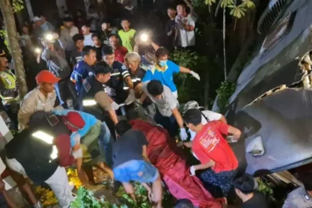 Petugas saat mengevakuasi jenazah kernet Bus Mira yang terjun ke parit di Jalan Nasional Ngawi-Solo masuk Desa Gemarang, Kedunggalar, Ngawi, Jawa Timur, Jumat (23/08/2024).