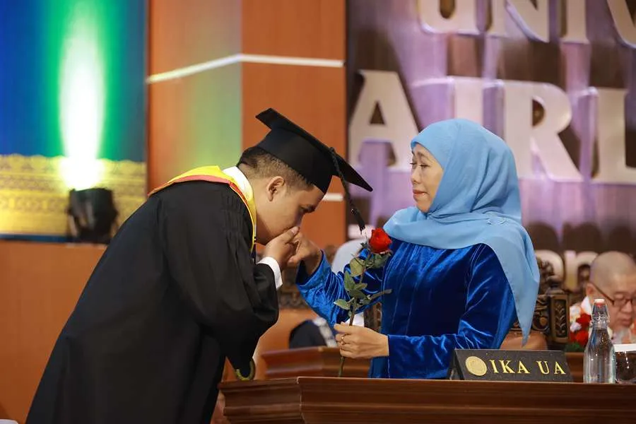 Momen Ali Mannagalli Parawansa mencium tangan Khofifah Indar Parawansa saat mengikuti prosesi wisuda di Universitas Airlangga.
