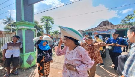 Seorang warga Bondowoso menerima bantuan beras dari Bulog setempat pada penyaluran Banpang beberapa waktu lalu. (Bulog Bondowoso)