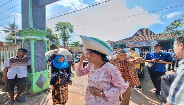 Seorang warga Bondowoso menerima bantuan beras dari Bulog setempat pada penyaluran Banpang beberapa waktu lalu. (Bulog Bondowoso)
