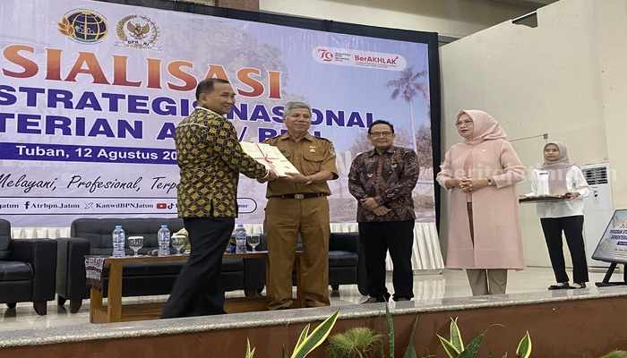 Kepala BPN Tuban saat menyerahkan sertifikat elektronik tanah aset milik Pemkab Tuban kepada BPKAD Tuban. [foto: Diah Ayu/beritajatim.com]