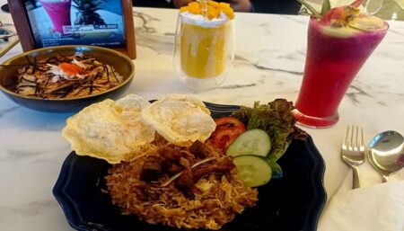 Nasi Goreng Kambing dan Salmon Mentaidon yang dipadukan dengan minuman tropical. (Fitri Yuliani/beritajatim.com)