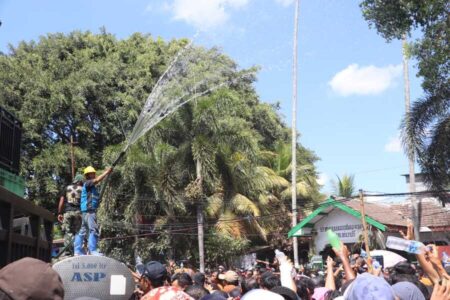 Pembagian air hasil jamasan Gong Kiai Pradah, Selasa (17/9/2024). (foto : Winanto/beritajatim.com)