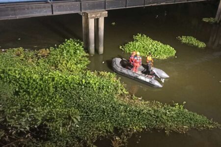 Petugas saat melakukan pencarian di sungai Jagir.