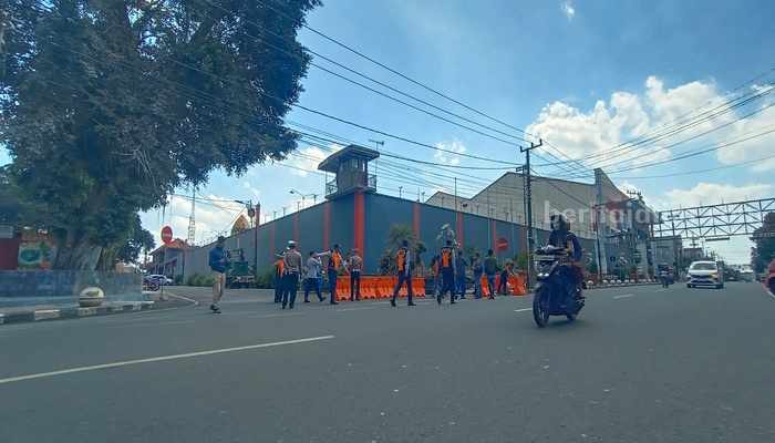 Petugas Dishub Kota Blitar melakukan penataan rambu lalu lintas di jalur yang dilakukan perubahan di sekitar Alun-alun Kota Blitar. Selasa (17/9/2024). (foto : Winanto/beritajatim.com)