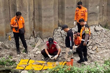 Dua Tengkorak dan Tulang Belulang Manusia Ditemukan di Pompa Air Surabaya Petugas kepolisian saat mengumpulkan tulang belulang yang ditemukan di pintu air Wonorejo, Surabaya.