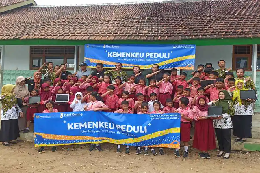 Puluhan siswa dan guru SDN 2 Karangpatihan berfoto bersama dengan rombongan dari DJP Jatim II dan KPP Pratama Ponorogo. (Foto/Endra Dwiono/Beritajatim.com)