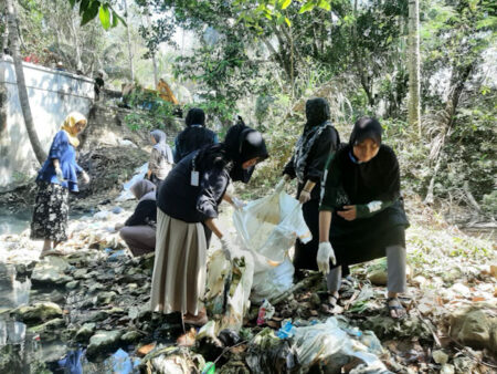 Mahasiswa KKN Annuqqyah bersih-bersih sampah sungai.