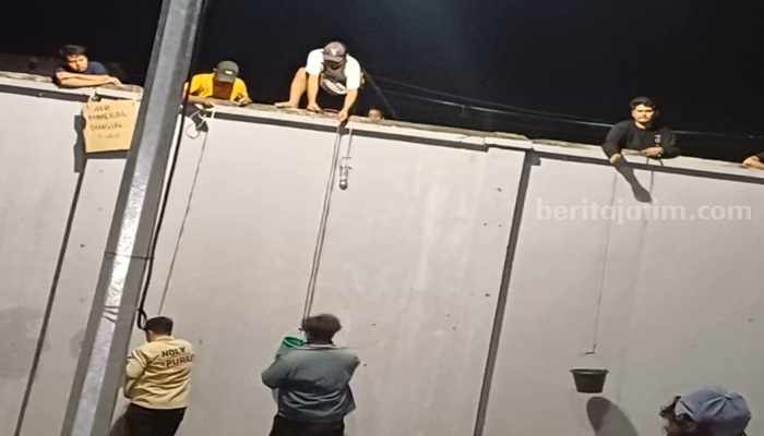 Potret warga lokal sekitar SBEC yang memanjat tembok untuk berjualan saat konser sedang berlangsung, Minggu (1/9/2024). (Fitri Yuliani/beritajatim.com)
